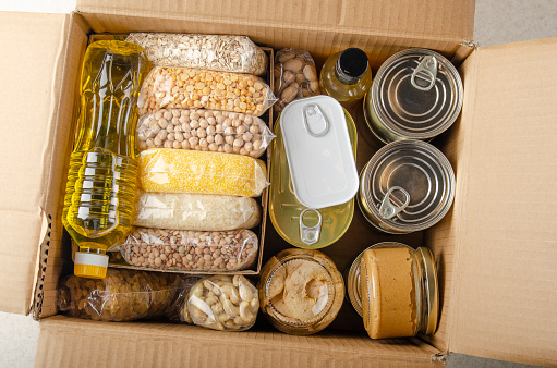Vista plana de los alimentos sin cocinar en caja de cartón preparada para condiciones de emergencia ante desastres o regalar photo