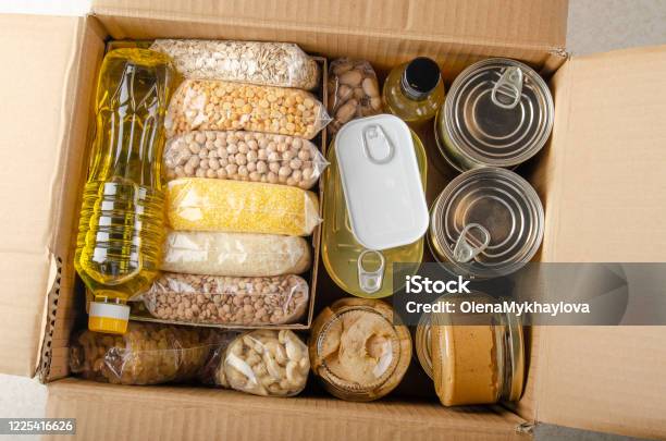 Flat Lay View At Uncooked Foods In Carton Box Prepared For Disaster Emergency Conditions Or Giving Away Stock Photo - Download Image Now