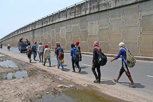 Burdwan Town, Purba Bardhaman District, West Bengal / India - May 17, 2020: Migrant workers stranded due to lockdown in the emergence of Novel Coronavirus (COVID-19) are walking from Barrackpore (West Bengal) to Bihar on their own initiative. Migrant workers are walking on the 2 no National Highway towards their destination. At Burdwan Town.
