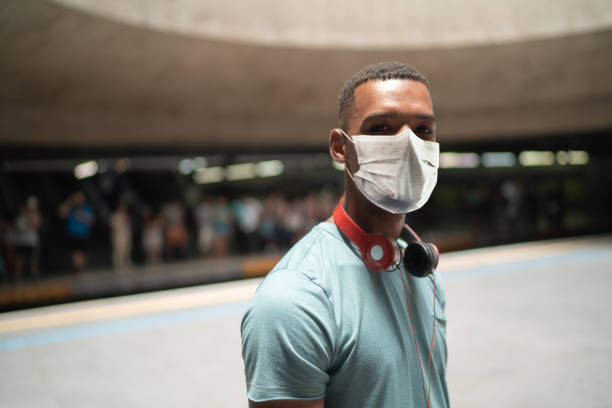 지하철 역에서 보호 마스크를 사용하는 젊은 남자의 초상화 - pollution mask audio 뉴스 사진 이미지