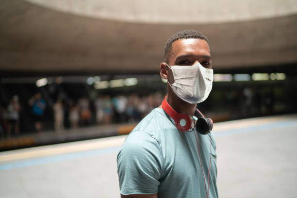 Portrait of a young man using protective mask at metro station