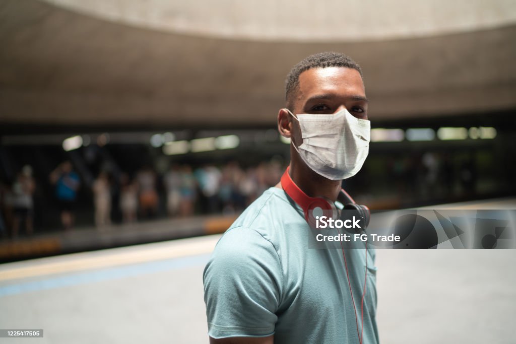 Portrait of a young man using protective mask at metro station Protective Face Mask Stock Photo