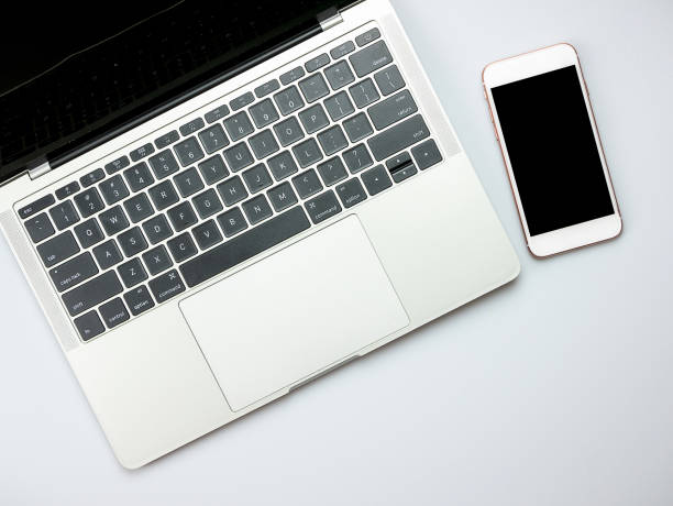 istock Modern white office desk table with laptop computer and smart phone. 1225424644