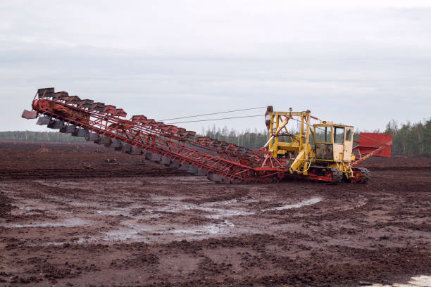 istock Peat or turf production: machine harvesting peat on the field 1225424863