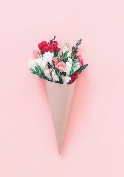 istock Roses bouquet in cone on pink background, flat lay, top view. 1225426475