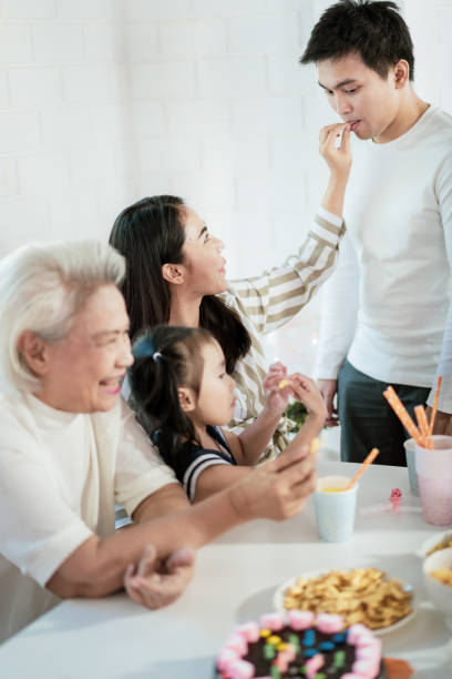 gruppo di famiglie asiatiche festa a casa con felicità - thai cuisine asian cuisine vertical close up foto e immagini stock