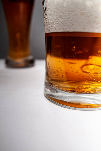 Closeup of pouring gold beer two on grey background for concept design. Summer concept.