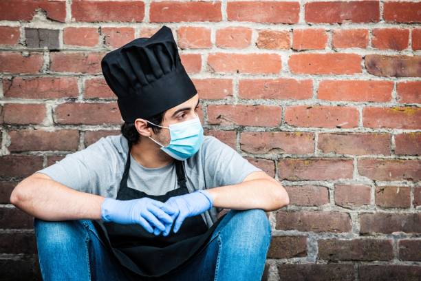 istock Young chef posing with a protective mask and gloves during a break looking away 1225429624