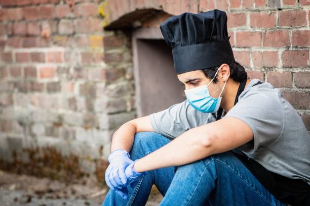 istock Young chef posing with a protective mask and gloves during a break looking down 1225431056