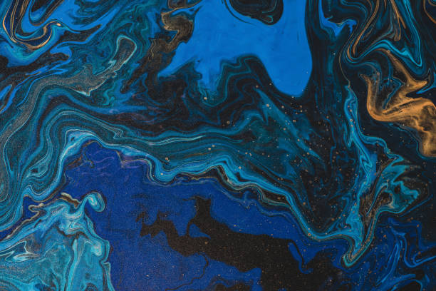 istock Fluorescent fluid art background in blue tints with gilding. Flowing wave effect of liquid ink. Dark phantom blue with golden dust. Abstract texture of acrylic paints. Surreal color mix. Gold on blue. 1225431298