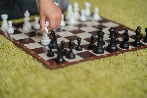 Close-up little boy plays chess in home quarantine
