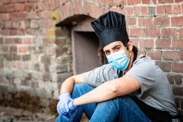 istock Young chef posing with a protective mask and gloves during a break looking at the camera 1225432683