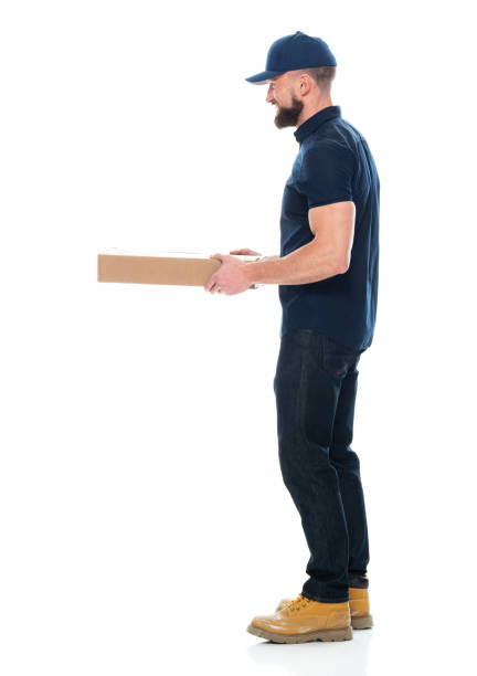 mano de pizza masculino caucásico de pie frente al fondo blanco usando gorra - sombrero y la celebración de comida rápida - attractive male men baseball cap male fotografías e imágenes de stock