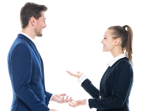 Profile view of aged 20-29 years old with brown hair caucasian female business person standing in front of white background wearing smart casual who is talking