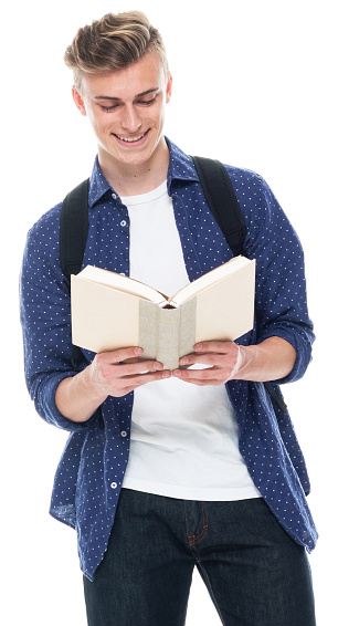 Portrait of aged 16-17 years old with brown hair caucasian male student standing in front of white background wearing shirt who is studying and holding book