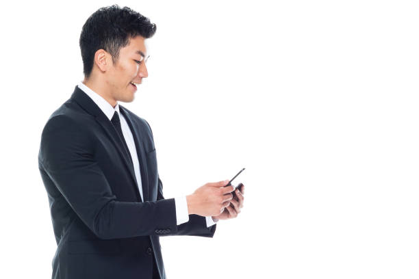 istock Chinese ethnicity male manager standing in front of white background and using digital tablet 1225437595