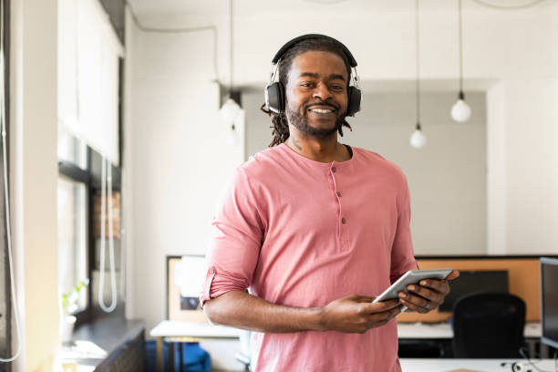 istock Modern Businessman Using Headphones and Tablet (Copy Space) 1225439245