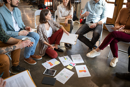 Group of modern casual businesspeople having brainstorming meeting and working in team.