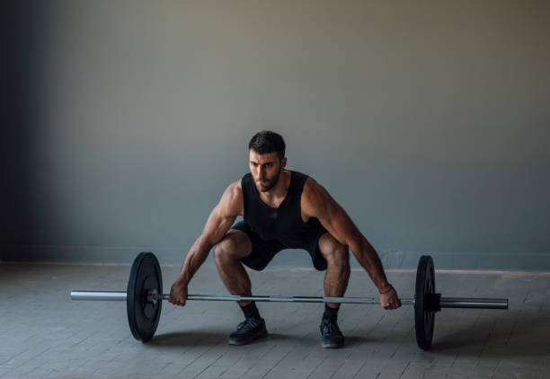 istock Weightlifting: a Strong Muscular Man Exercising with a Barbell 1225440097