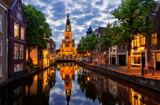 The city of Alkmaar, Netherlands, at night with houses along the Canal Luttik Oudorp and the Waag in the background