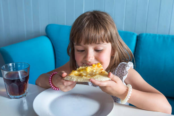 istock Little girl eats hot pizza in a restaurant. 1225441587
