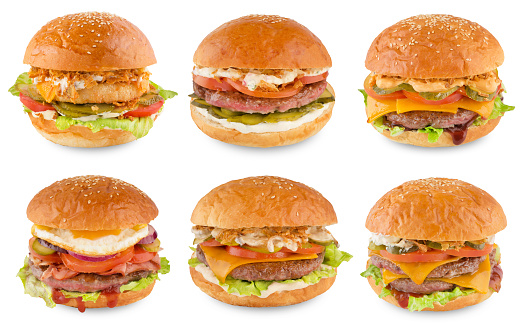 Stock photo showing close-up view of cheeseburger served in sesame seed burger bread bun in cardboard takeaway box.