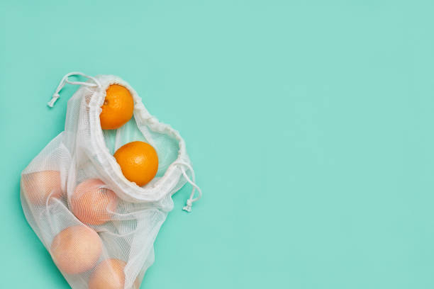 istock Zero waste concept. Tangerines in the package. Copyspace. Green background. 1225442696