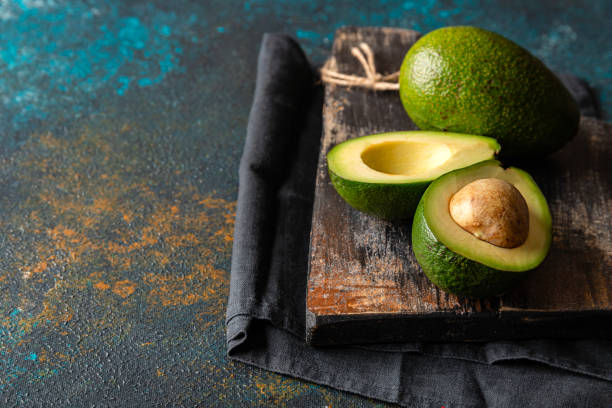 istock avocado on a dark rustic background on dark board with copy space for your text. 1225446133