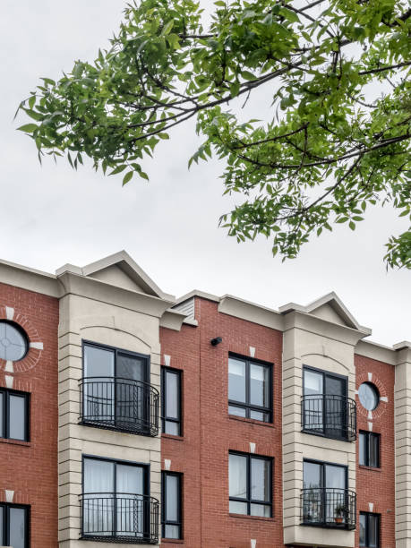 istock Green leaves and modern brick building 1225447486
