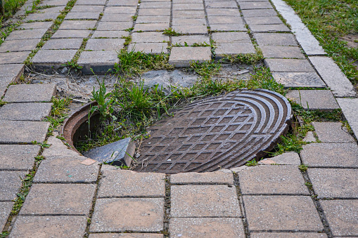 Destroyed cover sewage well on the sidewalk.