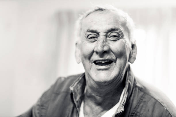 black and white portrait of laughing senior man, front view, background with copy space - portrait black and white senior men wisdom imagens e fotografias de stock