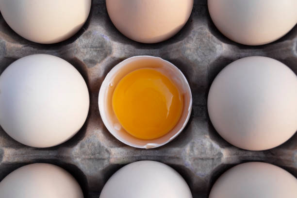 istock A chicken egg is half broken among other domestic eggs. 1225452517
