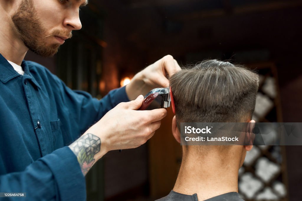Master Bearded Barber With Tattoo On His Hand Cutting Clients Hair With Hair  Clipper Barbershop Back View Stock Photo - Download Image Now - iStock