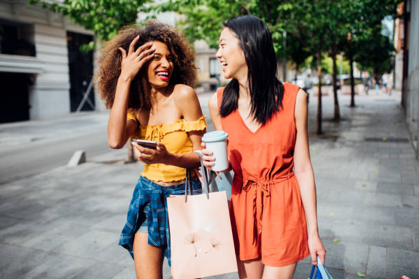 девушки возвращаются из магазинов и веселиться - disposable cup coffee shopping friendship стоковые фото и изображения