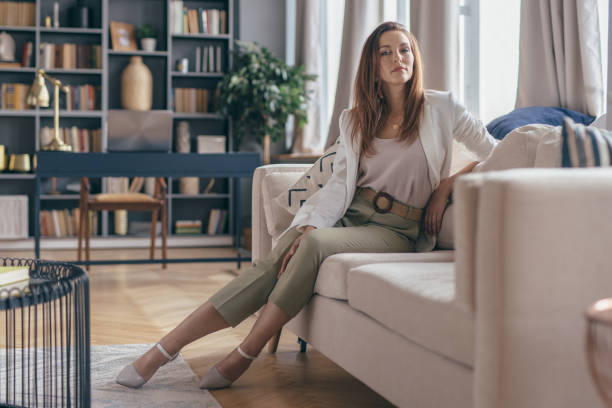 femme dans la tenue d’affaires après le travail à la maison reposant sur le divan. - gracious photos et images de collection