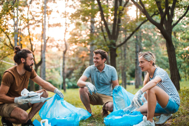 istock Three friends collecting garbage from the park 1225459071