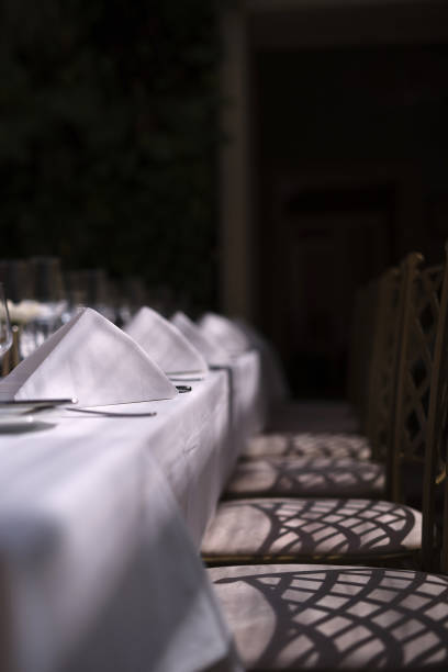 istock The table is covered with a white tablecloth; cloth napkins are lying. Beautiful patterns on the floor, beautiful shadows. 1225462589
