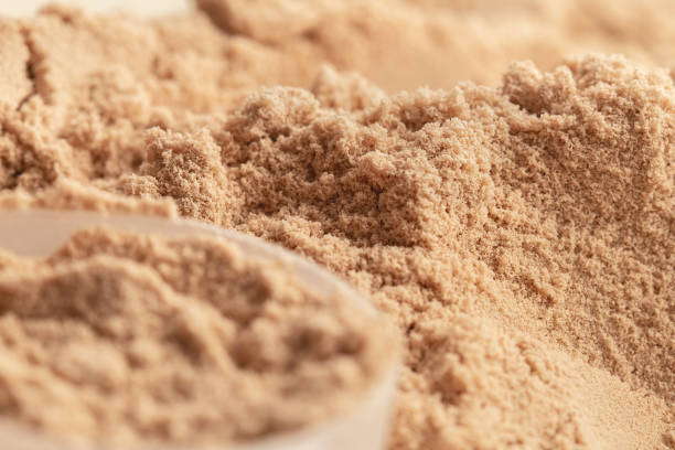Chocolate flavor whey protein powder in close-up. Chocolate flavor whey protein powder in close-up. proteína stock pictures, royalty-free photos & images