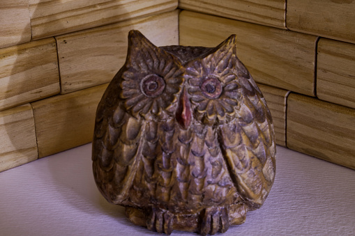 carved wooden owl in a gloomy composition
