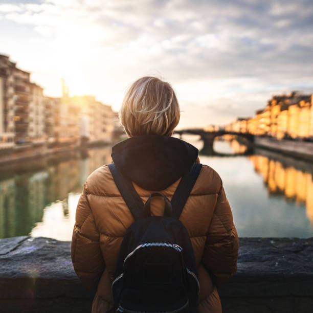 istock Tourist looking at Arno river from Ponte Vecchio in Florence 1225464211