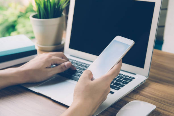 istock Hand of business man working from home using laptop computer to internet online on desk, lifestyle of new normal, social distancing, freelance work in stay home and look phone, communication concept. 1225468018