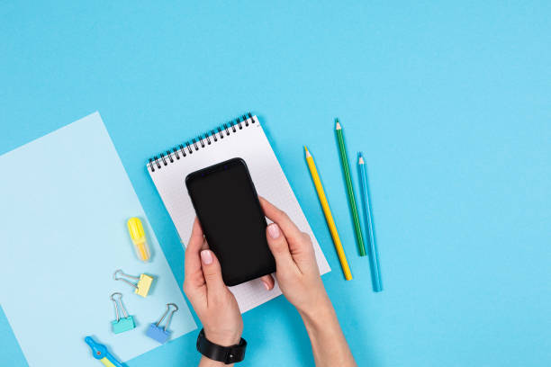 istock Mobile phone and different stationery isolated on whitte and blue background 1225469425