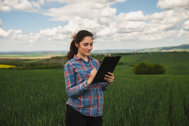 istock Young female agriculture scientist checking wheat crops on the field 1225469936