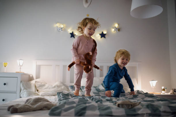 istock Two small children jumping on bed indoors at home, having fun. 1225470514