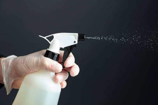 istock Man's hand in rubber glove sprays disinfectant. 1225472483