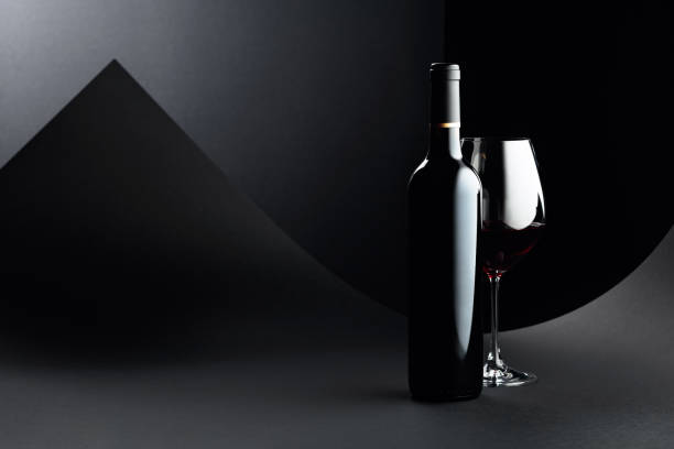 istock Bottle and glass of red wine on a dark background. 1225472500