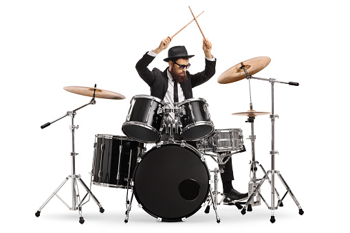 Drummer starting to play drums and holding drumsticks in the air isolated on white background