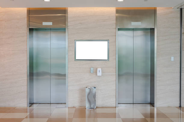 два лифта в торговом центре и офисном здании, с белой рекламной доской - sign station contemporary escalator стоковые фото и изображения