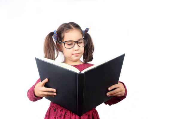 istock Cute Little girl reading book on white background 1225491154
