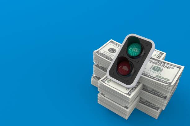 istock Green traffic light on stack of money 1225493908